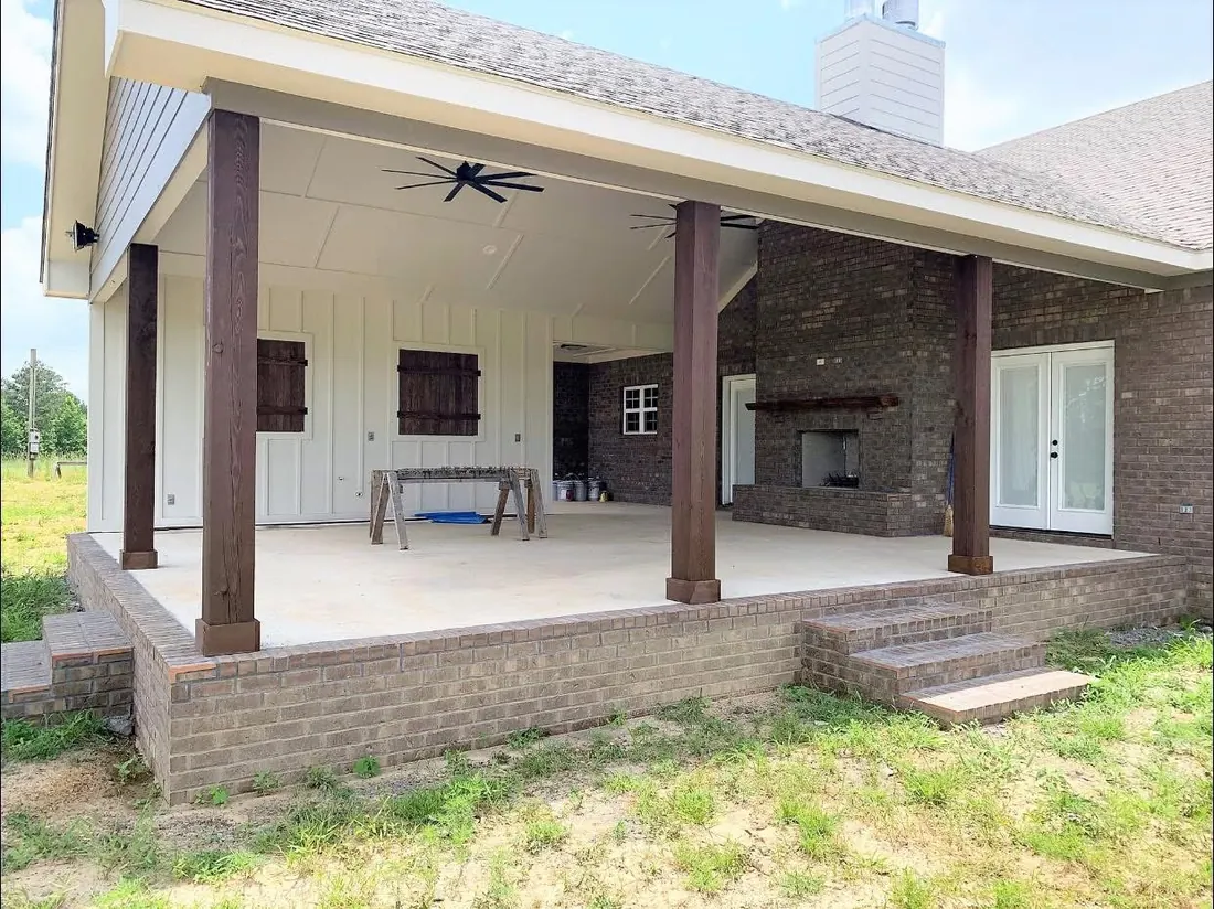 Covered back porch on brick with wood columns, a ceiling fan and an outdoor fireplace