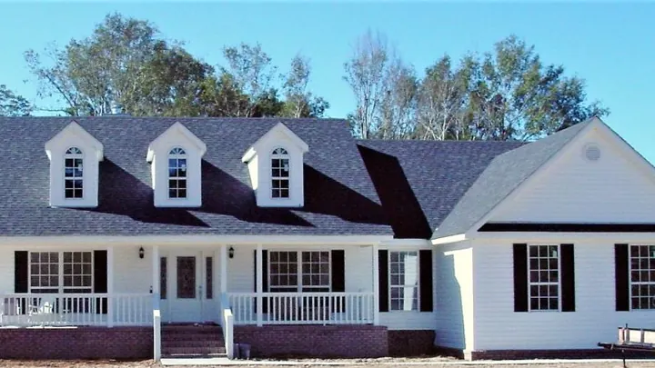 The Aspen plan: white home with three dormers and a railed front porch
