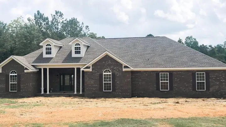 The Magnolia plan: dark brick home with dormers and arched windows